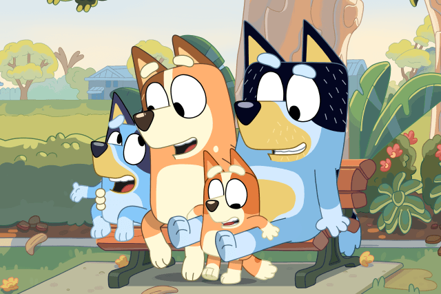 Image of the Heeler family from Bluey. They are sitting on a park bench together. PHOTO COURTESY OF LUDO STUDIOS