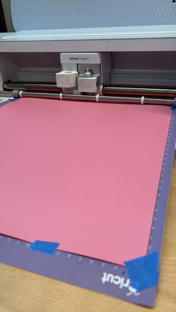 the Cricut paper being loaded in to cut.